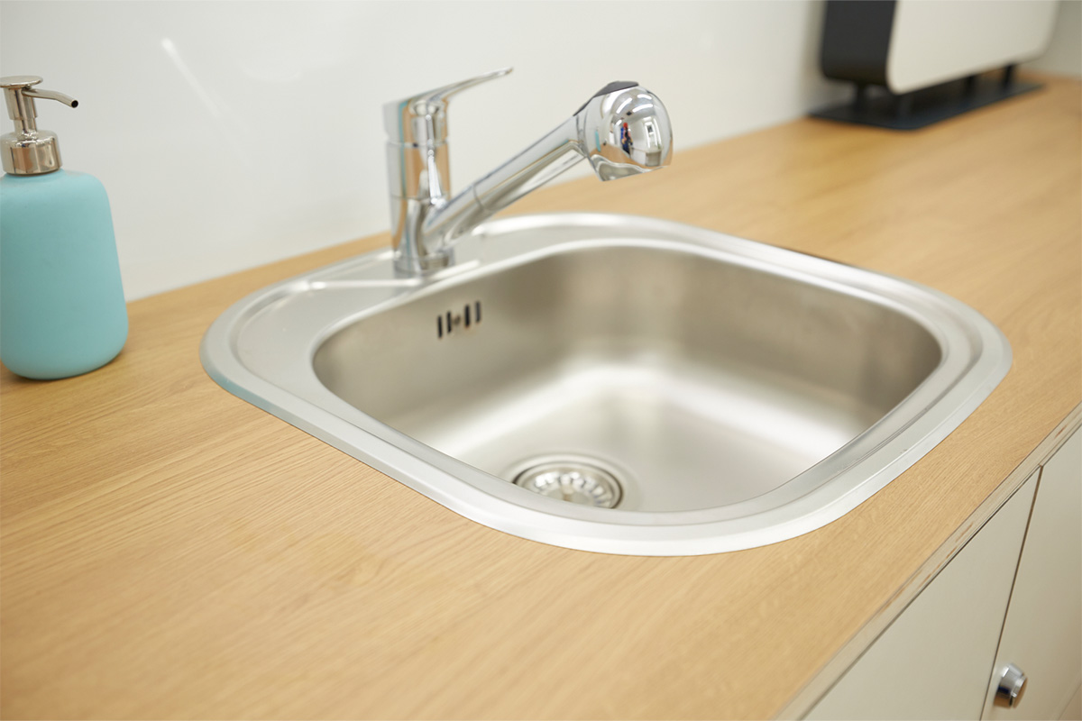 Stainless steel washbasin with hot water tap. 